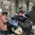 Familiares alrededor de las camas de los enfermos en la zona de Urgencias del Hospital nº 4 de Langfang, en la ciudad de Bazhou (Hebei, China).