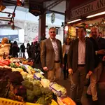 El presidente de la Junta de Andalucía Juanma Moreno (1d) y el candidato a la alcaldía de Sevilla José Luis Sanz (1i) pasean por la plaza de abastos de Triana. Joaquín Corchero / Europa Press
