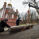 Miembros del equipo de desminado del Servicio Estatal de Emergencias cargan los restos de un misil en un camión especial de desminado en las afueras de Kyiv