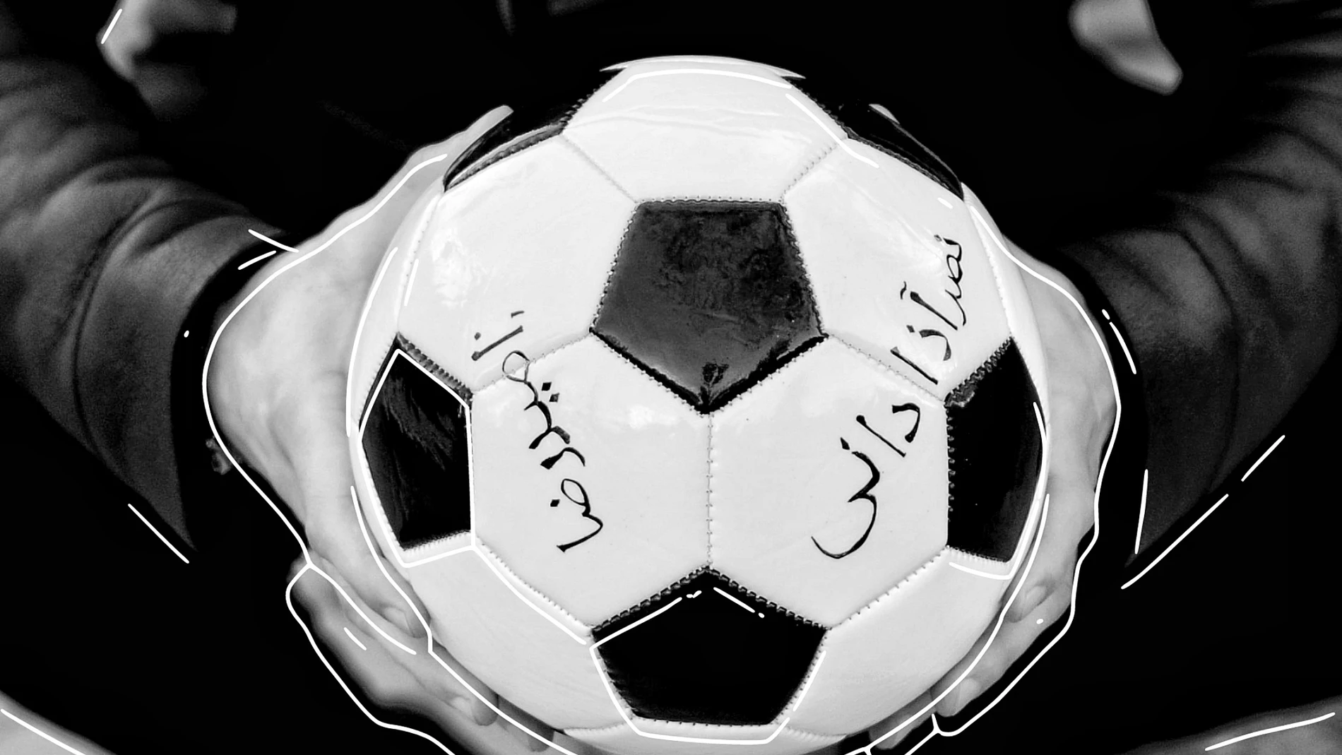 En el balón lanzado por el artista Omar Jerez se pueden leer los nombres de Amir Nars Azadani y de Mahsa Amin escritos en persa