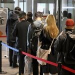 Pasajeros de Shanghái hacen fila para hacerse una prueba de COVID-19 a su llegada al aeropuerto de Narita, cerca de Tokio