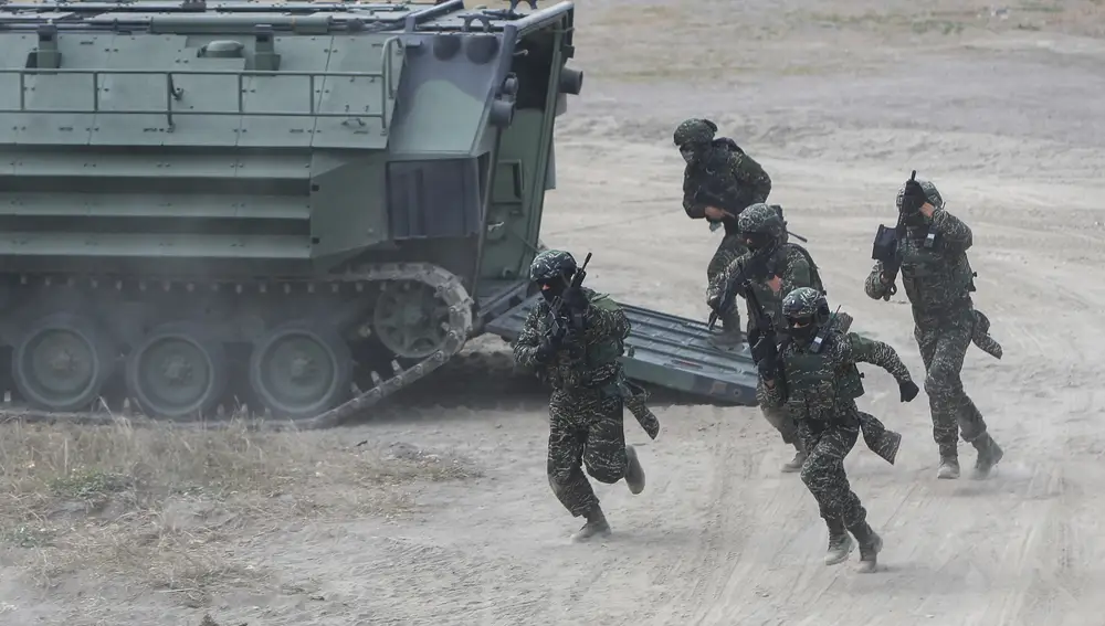 Soldados se apresuran a bajar de un vehículo anfibio de asalto durante un ejercicio militar en la ciudad de Kaohsiung, Taiwán