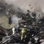 Bomberos tratan de buscar supervivientes tras el bombardeo de un edificio residencial en Dnipro, sureste de Ucrania