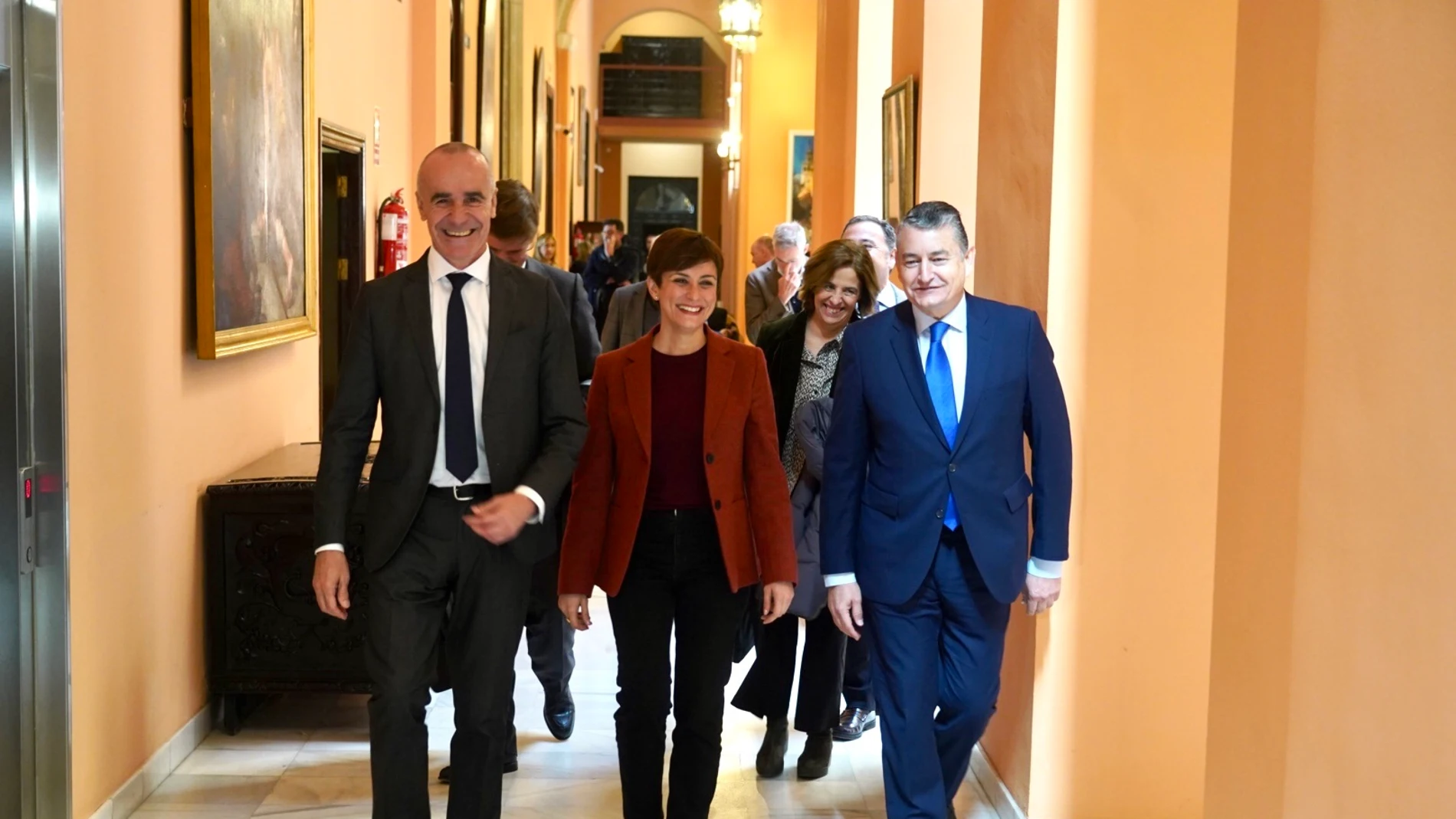 El alcalde de Sevilla, Antonio Muñoz; la ministra de Política Territorial, Isabel Rodríguez, y el consejero de Presidencia, Antonio Sanz, en los pasillos del Ayuntamiento de Sevilla