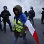 Un manifestante pasa junto a varios agentes de policía en París