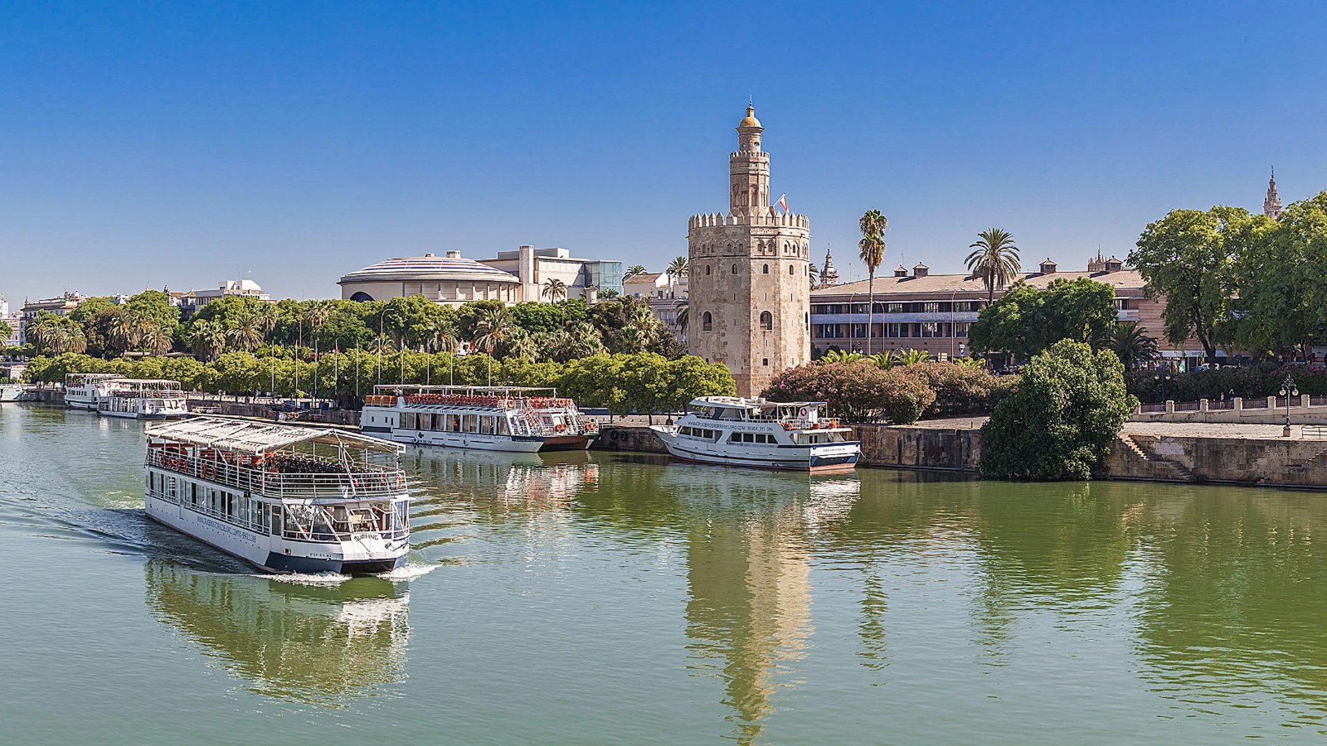 Un barco de Cruceros Torre del Oro navegando en el río Guadalquivir de Sevilla
