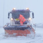 Una máquina quitanieves circula este martes por el Puerto de Navacerrada en la primera nevada del año