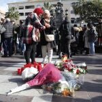 Dos mujeres colocan una vela en el sitio donde asesinaron al sacristán Diego Valencia de la iglesia de la Palma en Algeciras (Cádiz)