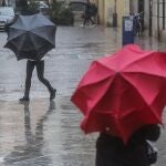 Imagen de archivo de dos personas sostenido paraguas a causa de la lluvia