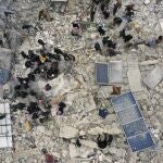 Civil defense workers and residents search through the rubble of collapsed buildings in the town of Harem near the Turkish border, Idlib province, Syria, Monday, Feb. 6, 2023. A powerful earthquake has caused significant damage in southeast Turkey and Syria and many casualties are feared. Damage was reported across several Turkish provinces, and rescue teams were being sent from around the country. 