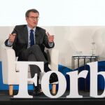 El líder del PP, Alberto Núñez Feijóo en la IV edición de Forbes Summit junto al conductor del acto.