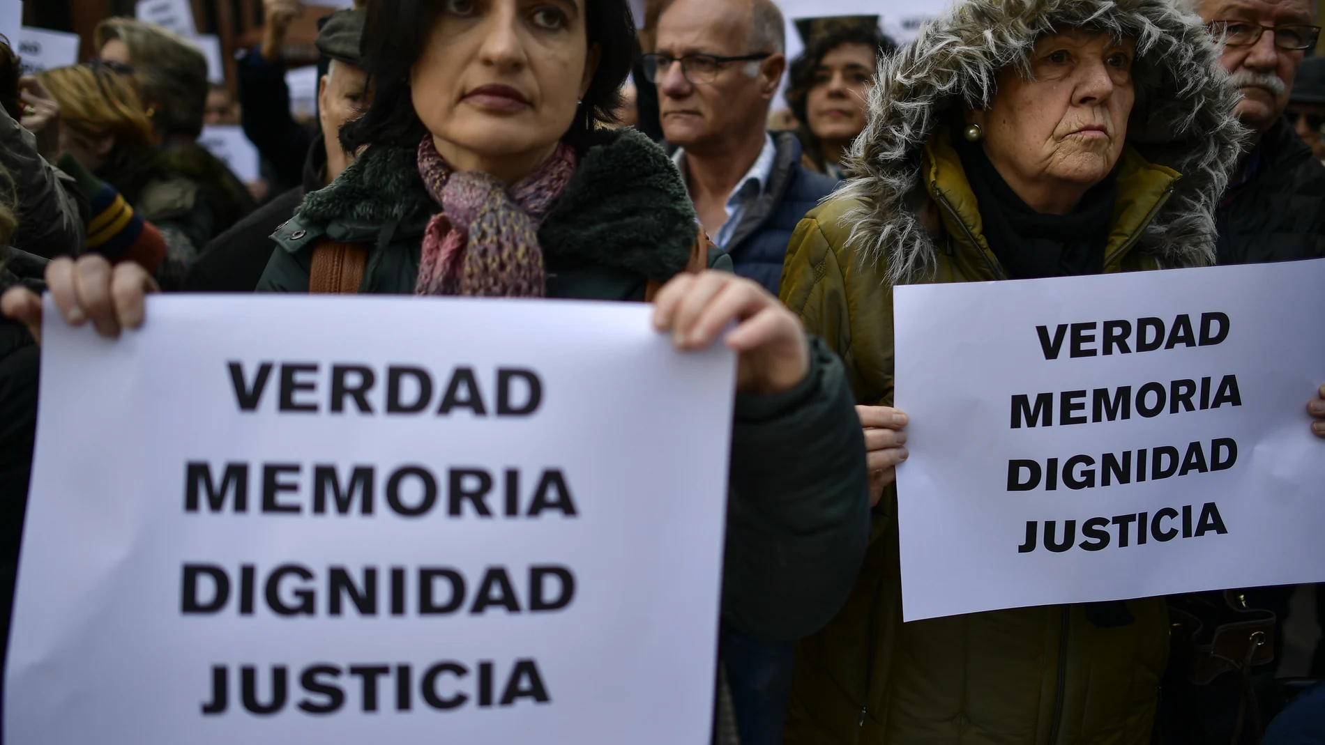 Relatives of people killed by the dissolved basque armed group ETA, brandish banners reading ''True, Memory, Dignity, Justice'', in tribute of their victims, in Pamplona, northern Spain, Friday, Dec. 28, 2018. Every year during Christmas days, relatives of the victims of ETA gather to condemn the actions of the armed group.