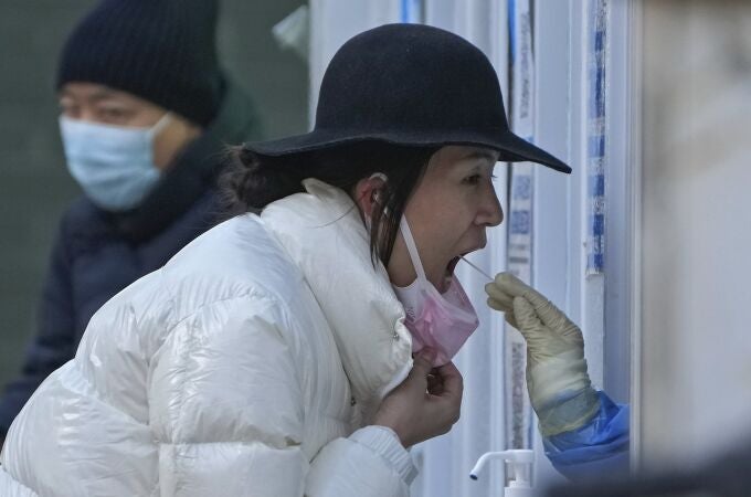 A woman has her routine COVID-19 throat swab at a coronavirus testing site in Beijing