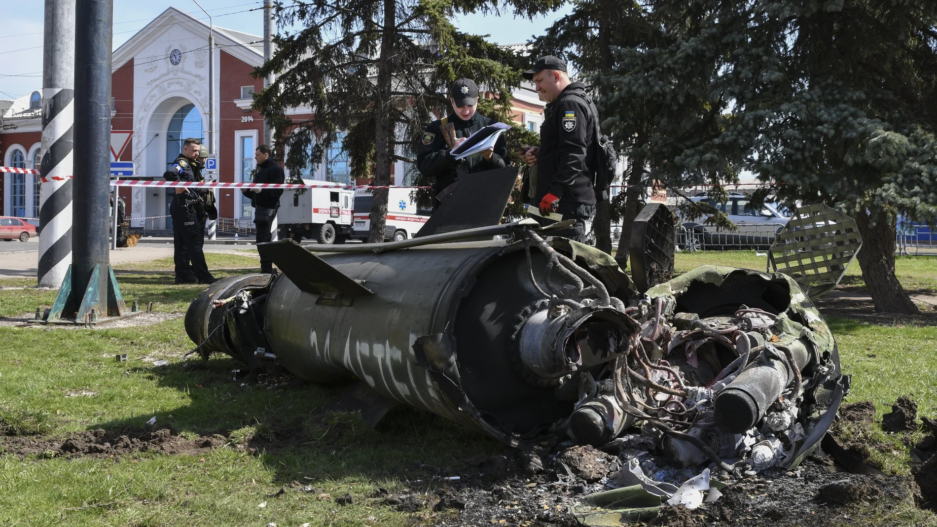 Militares ucranianos junto a un fragmento de misil Tochka-U con la inscripción en ruso "For children" ("Para los niños"), sobre la hierba tras un bombardeo ruso en la estación de ferrocarril de Kramatorsk (Ucrania)