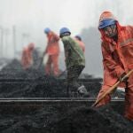  Varios trabajadores bajo la nieve en una estación de tren en China