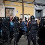 Varias personas intentar evitar el desalojo de la policía de una nave industrial okupada que se encuentra en desuso en la calle Progrés de Badalona (Barcelona)