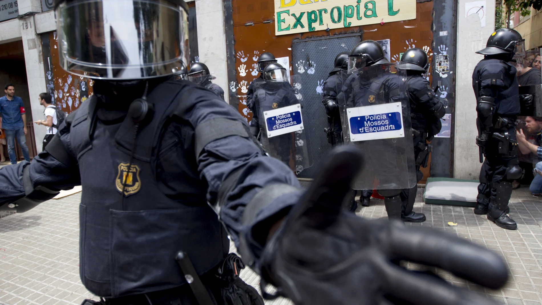 GRA196. BARCELONA, 04/06/2016.- Agentes antidisturbios de los Mossos han rodeado los accesos del llamado "Banco Expropiado" de Barcelona tras dispersar a empujones al centenar de personas que se habían concentrado a las puertas de la finca, en apoyo a los okupas que, según aseguran, han vuelto a entrar en el inmueble. EFE/Quique García