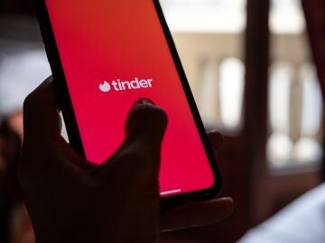 Una persona sostiene un m&oacute;vil que tiene instalada la aplicaci&oacute;n de Tinder