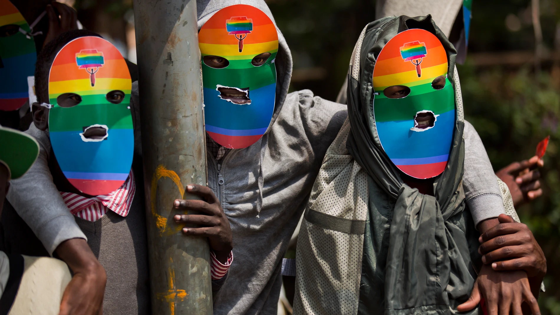 FILE - Kenyan gays and lesbians and others supporting their cause wear masks to preserve their anonymity as they stage a rare protest against Uganda's tough stance against homosexuality and in solidarity with their counterparts there, outside the Uganda High Commission in Nairobi, Kenya on Feb. 10, 2014. Ugandan lawmakers passed a bill Tuesday, March 21, 2023 prescribing jail terms of up to 10 years for offenses related to same-sex relations, responding to popular sentiment but piling more pressure on the East African country's LGBTQ community. (AP Photo/Ben Curtis, File)