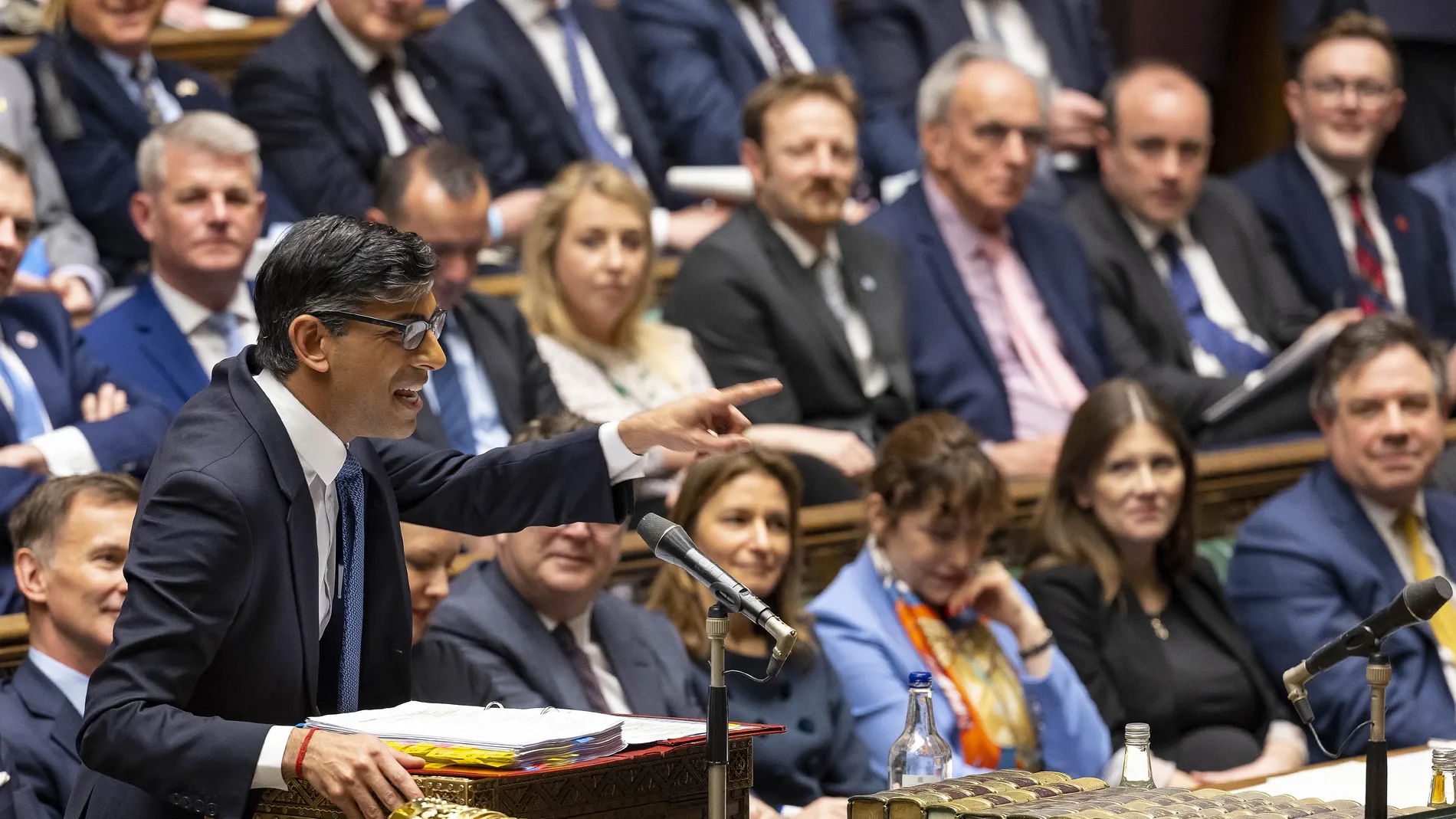A handout photograph released by the UK Parliament shows Britain's Prime Minister Rishi Sunak standing at the despatch box and speaking during the weekly session of Prime Minister's Questions (PMQs) at the House of Commons, in London, on March 22, 2023.