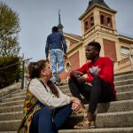 Silvia de Balimaya, trabajadora de un piso de acogida de la archicofradía del Rosario posa en la Basílica de Atocha con Abdul y Mandla, jóvenes africanos tutelados.