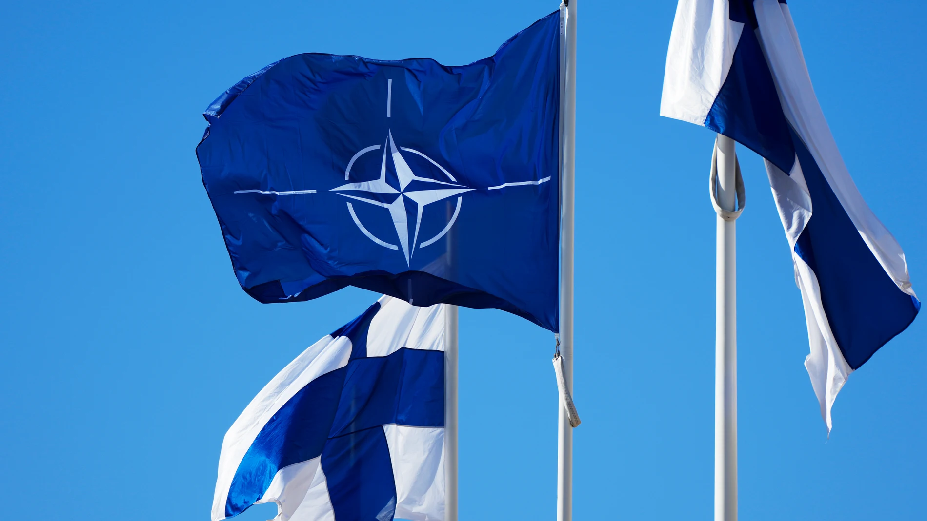 NATO flag, centre, and Finland flags flutter over the building of Ministry of Internal Affairs in Helsinki, Finland, Tuesday, April 4, 2023. Finland prepared to make its historic entry into NATO Tuesday, a step that doubles the Western alliance’s border with Russia and ends decades of non-alignment for the Nordic nation. (AP Photo/Sergei Grits)