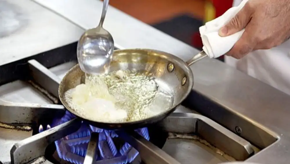 Cuando inclinamos la sartén para cocinar los huevos, lo que conseguimos es que el huevo pueda sumergirse casi por completo, de forma que haya más superficie en contacto directo con el aceite