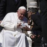 Pope Francis caresses a statuette of the Virgin Mary as he leaves at the end of his weekly general audience in St. Peter's Square, at the Vatican, Wednesday, April 26, 2023.