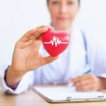 Portrait of woman doctor with holding red heart.