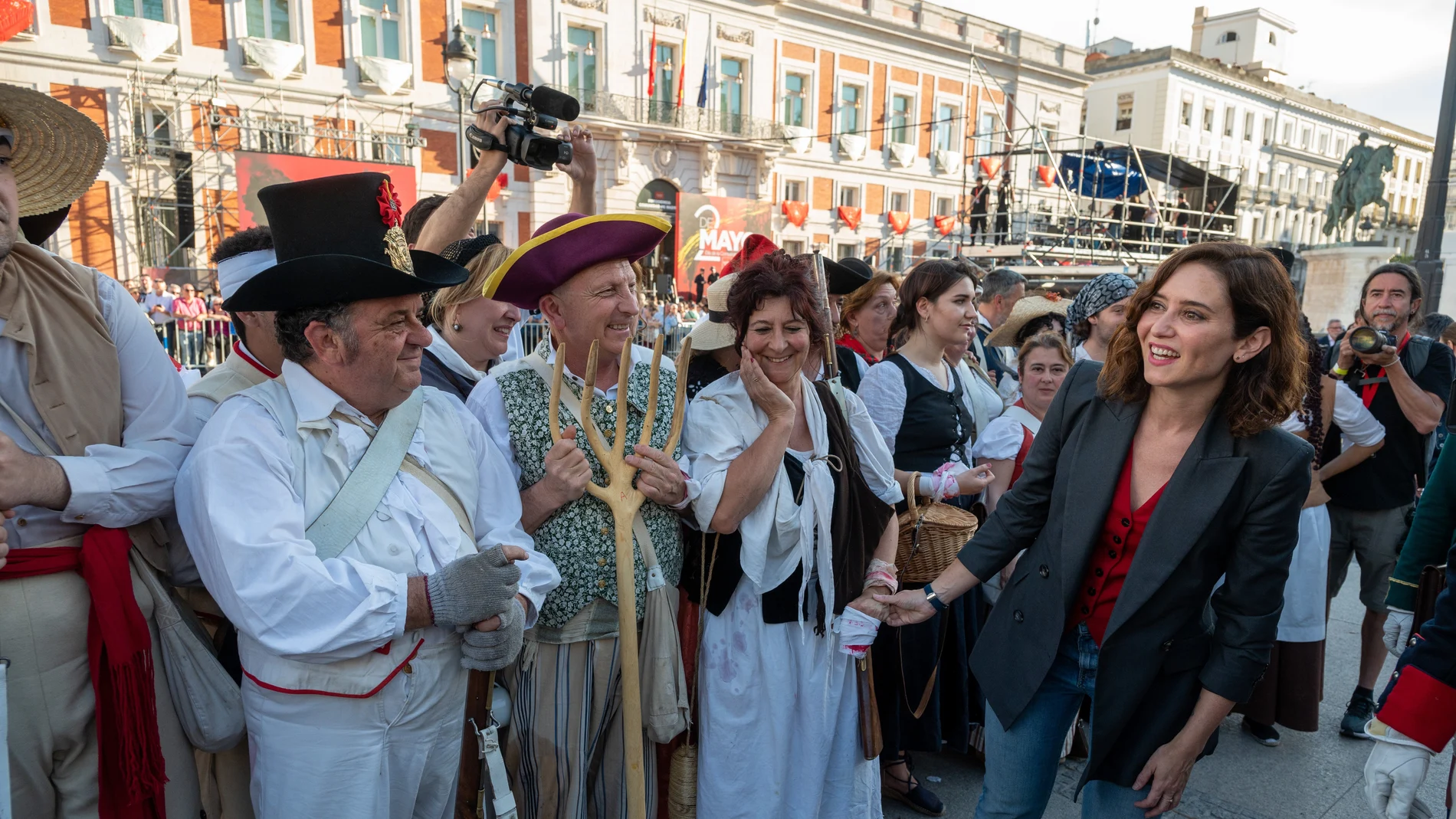 La presidenta de la Comunidad de Madrid, Isabel Díaz Ayuso (d), asiste a la recreación histórica de la defensa del cuartel de Monteleón, a cargo de la Asociación Histórico-Cultural de Voluntarios de Madrid, dentro de los actos de celebración de las fiestas del 2 de Mayo, este lunes en la madrileña Puerta del Sol.