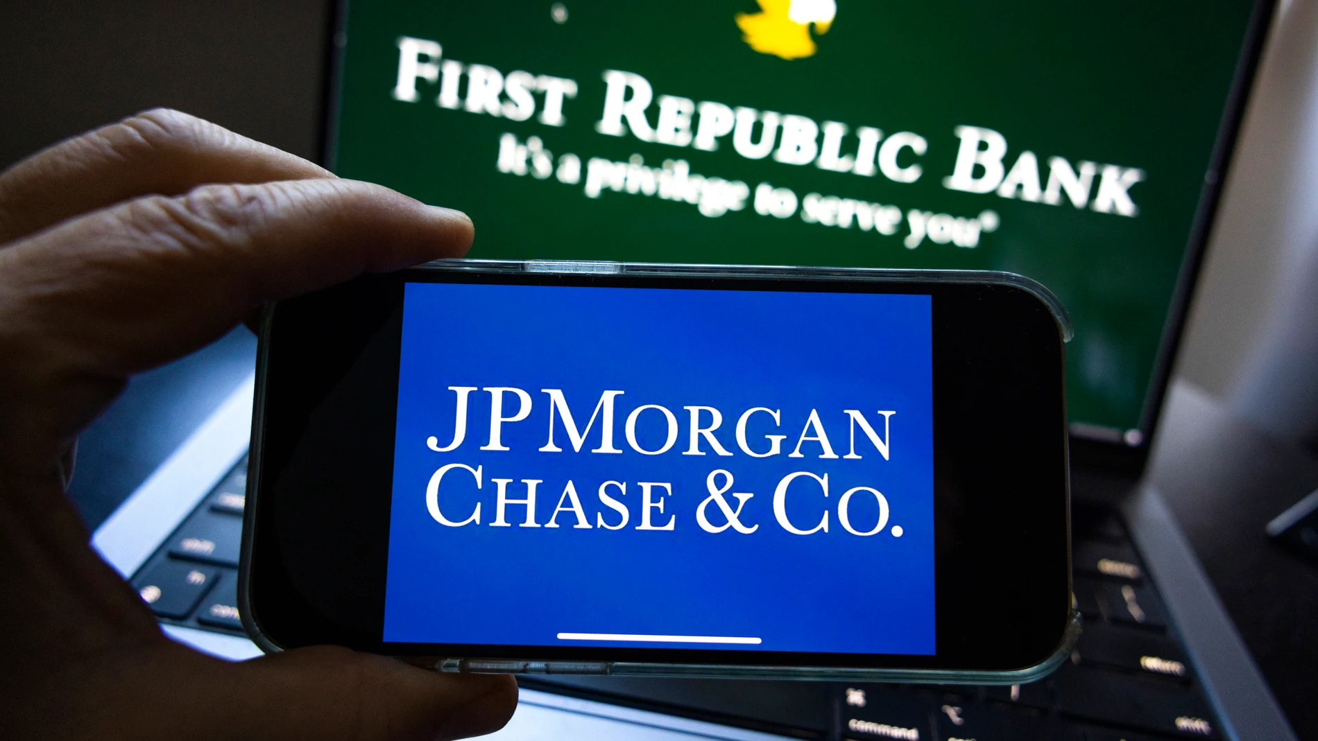 Washington (United States), 01/05/2023.- A photo illustration shows the JP Morgan Chase & Co corporate logo on a mobile device in front of a laptop with the First Republic Bank logo in Washington, DC, USA, 01 May 2023. The Federal Deposit Insurance Corporation (FDIC) announced it sold the failing First Republic Bank to JP Morgan Chase & Co shortly before markets were set to open. (Abierto, Estados Unidos) EFE/EPA/JIM LO SCALZO