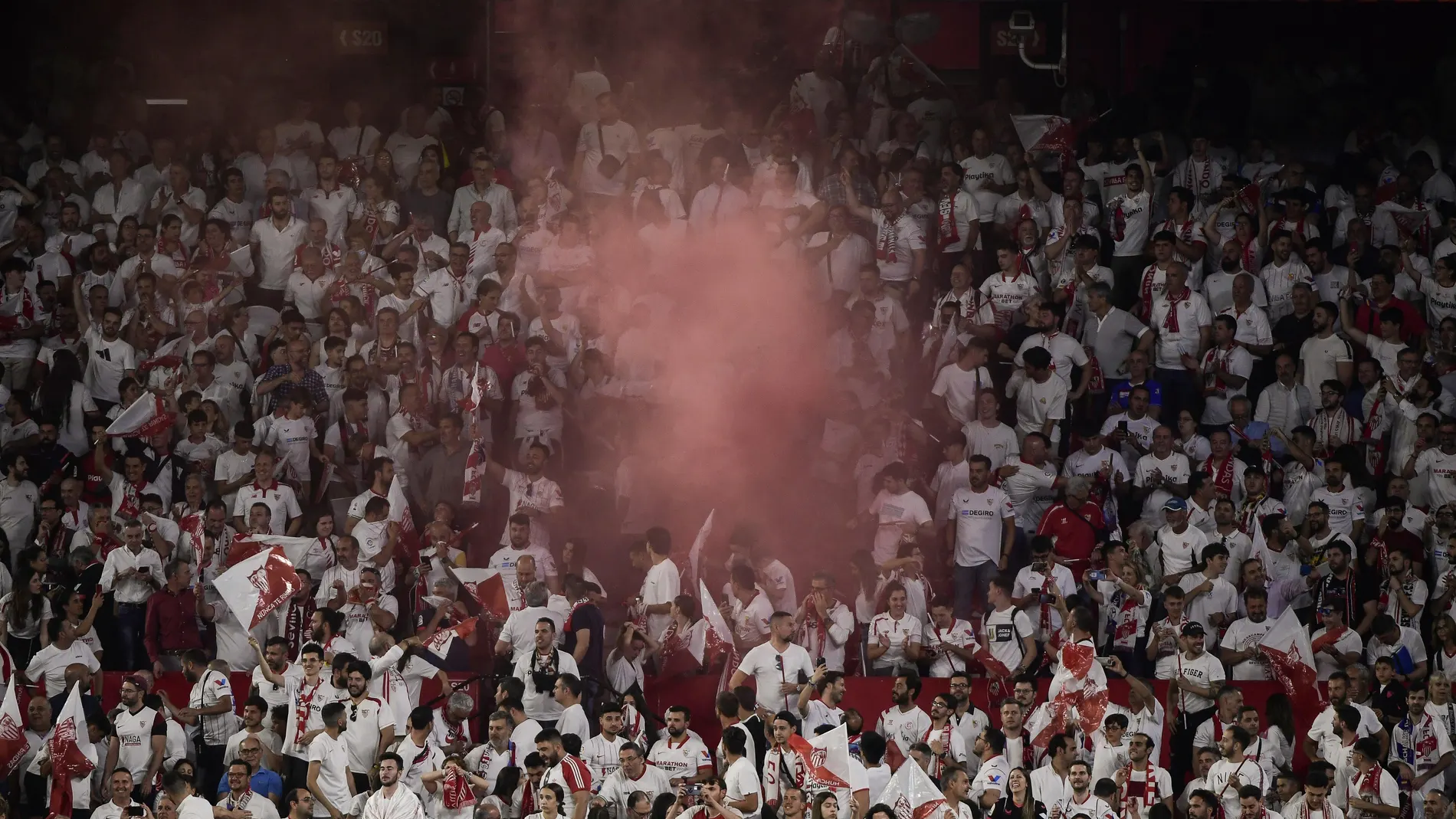 Sevilla's supporters light flares at the end of the UEFA Europa league quarter final second Leg football match between Sevilla and Manchester United at the Ramon Sanchez-Pizjuan stadium in Seville on April 20, 2023.
