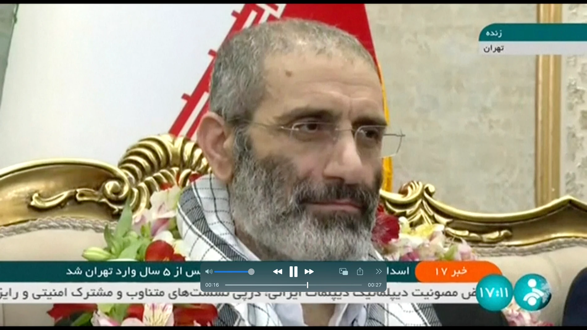 In this frame grab from video footage released Friday, May 26, 2023, by Iran state TV, IRINN, Assadollah Assadi, an Iranian diplomat who was released in a prisoner swap with Belgium, sits upon arrival at the Mehrabad airport in Tehran, Iran. Belgium and Iran exchanged prisoners on Friday in a controversial move that saw an Iranian diplomat convicted of attempting to bomb exiles in France bedecked in flowers on his return to Tehran while an aid worker was heading back to Brussels. (IRINN via AP)