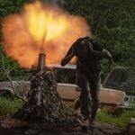 A Ukrainian soldier covers his ears while firing a mortar at Russian positions on the frontline near Bakhmut, Donetsk region, Ukraine, Monday, May 29, 2023. 