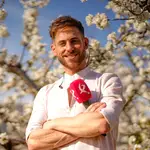 El presentador Cesar Muñoz delante de un almendro en flor en el Valle del Jerte