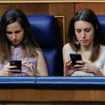 Irene Montero y Ione Belarra miran sus móviles en el Congreso