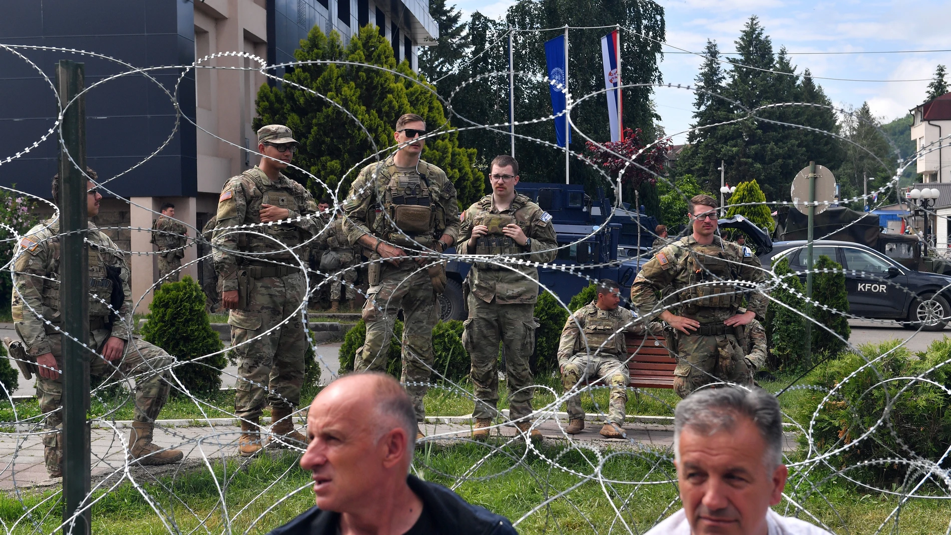 Leposavic (Serbia), 02/06/2023.- People sit in front of soldiers of the US contingent of the NATO-led international peacekeeping Kosovo Force (KFOR) while they take positions in front of the municipality building in Leposavic, Kosovo, 02 June 2023. At least thirty KFOR peacekeepers and fifty two civilians were injured in clashes between security forces and ethnic Serbs in Zvecan on 29 May 2023. Tensions continue in northern Kosovo'Äôs region, with majority of ethnic Serbian people, which arose after ethnic Albanians mayors took offices in four towns following elections boycotted by Serbian community. (Elecciones) EFE/EPA/GEORGI LICOVSKI