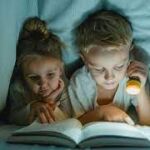 Lectura nocturna de dos niños