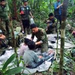  Fotografía cedida hoy por las Fuerzas Militares de Colombia que muestra a soldados e indígenas mientras atienden a los niños rescatados tras 40 días en la selva, en Guaviare (Colombia). Los cuatro niños que estaban perdidos desde el pasado 1 de mayo en las selvas del sur de Colombia tras el accidente del avión en el que viajaban junto a tres adultos fueron hallados con vida este viernes por militares que participaron en su búsqueda, informaron fuentes oficiales.