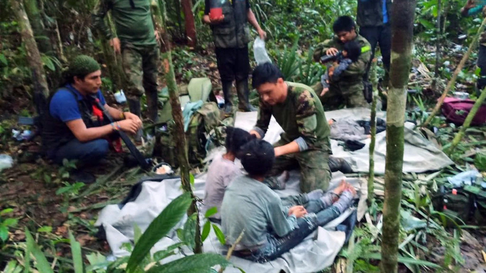 Fotografía cedida hoy por las Fuerzas Militares de Colombia que muestra a soldados e indígenas mientras atienden a los niños rescatados tras 40 días en la selva, en Guaviare (Colombia). Los cuatro niños que estaban perdidos desde el pasado 1 de mayo en las selvas del sur de Colombia tras el accidente del avión en el que viajaban junto a tres adultos fueron hallados con vida este viernes por militares que participaron en su búsqueda, informaron fuentes oficiales.