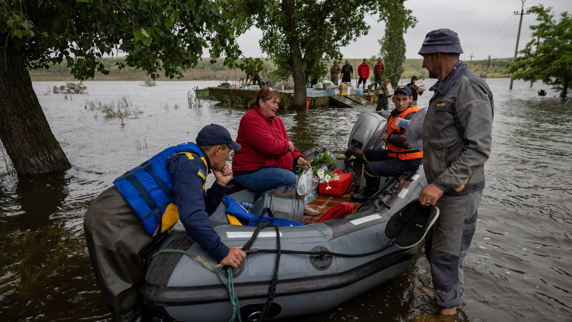 Rescue workers help locals to get home in the village of Afanasiivka, Mykolaiv region, Ukraine, 12 June 2023, amid floods following the collapse of a major dam. Ukraine has accused Russian forces of destroying a critical dam and hydroelectric power plant on the Dnipro River in the Kherson region along the front line in southern Ukraine on 06 June.
