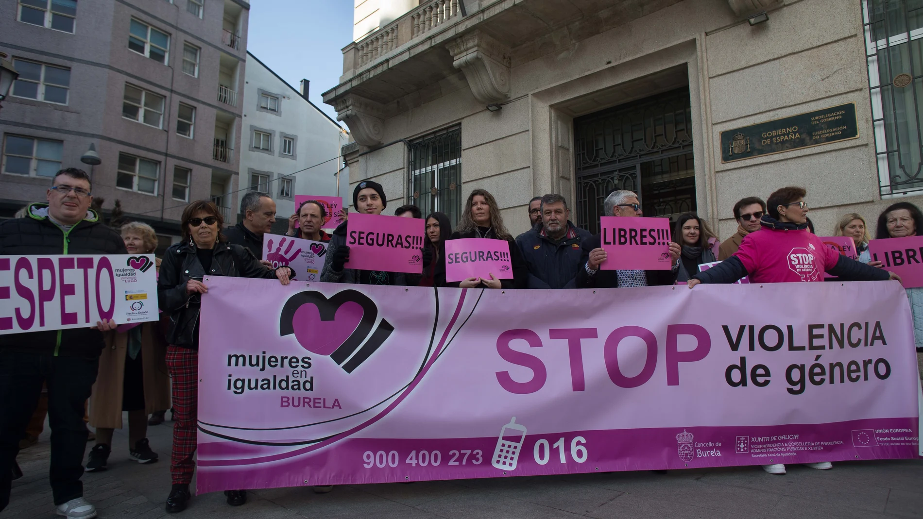 Varias personas con una pancarta en la que se lee: 'Stop violencia de género', participan durante una concentración convocada por la asociación ‘Mujeres en Igualdad', ante la Subdelegación del Gobierno en Lugo