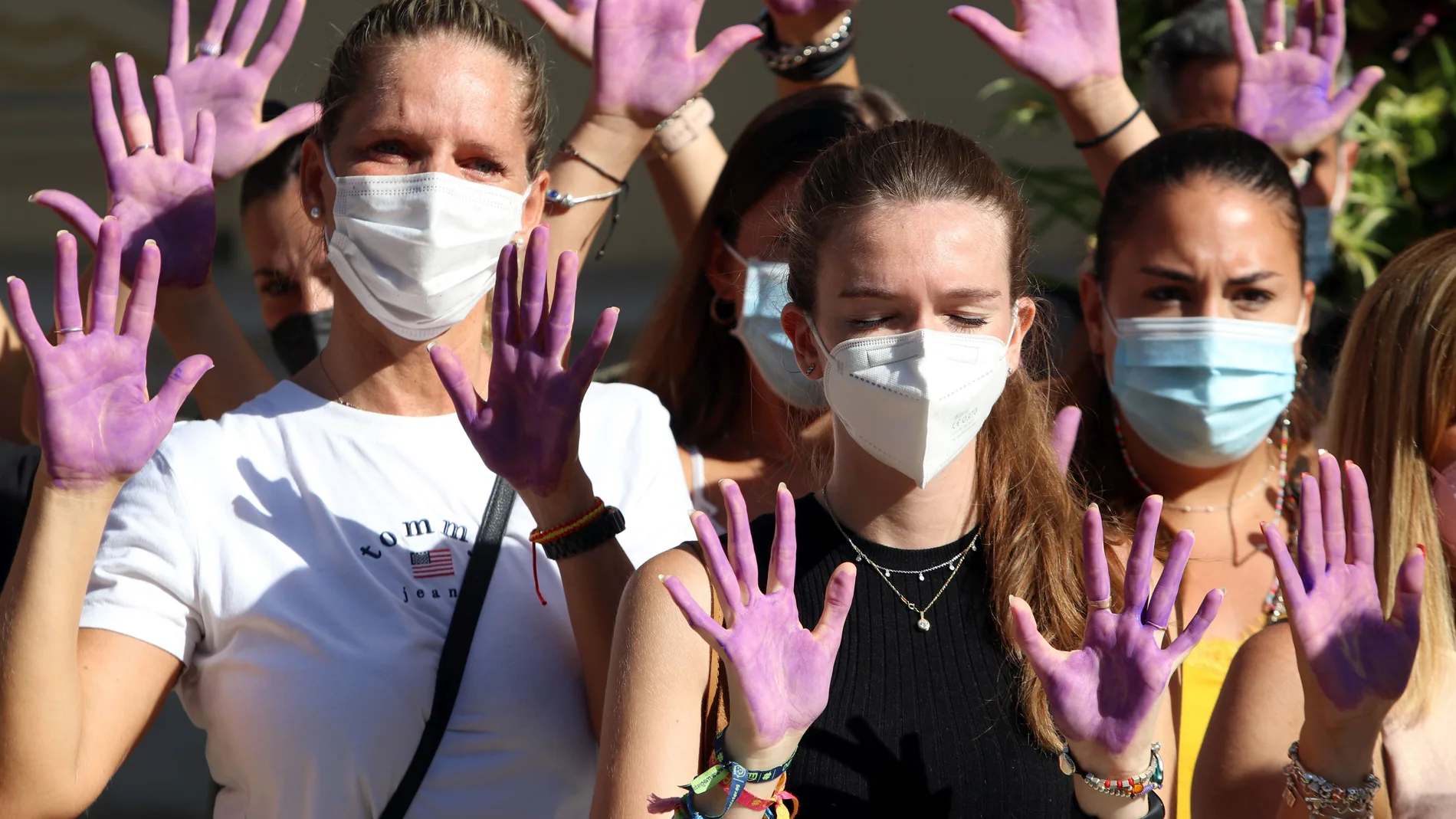 Varias mujeres con las manos pintadas guardan un minuto de silencio por las víctimas de la violencia machista