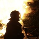 A riot police officer is silhouetted as he walks in front of a fire on the third night of protests sparked by the fatal police shooting of a 17-year-old driver in the Paris suburb of Nanterre, France, Thursday, June 29, 2023. The June 27 shooting of the teen, identified as Nahel, triggered urban violence and stirred up tensions between police and young people in housing projects and other neighborhoods. 