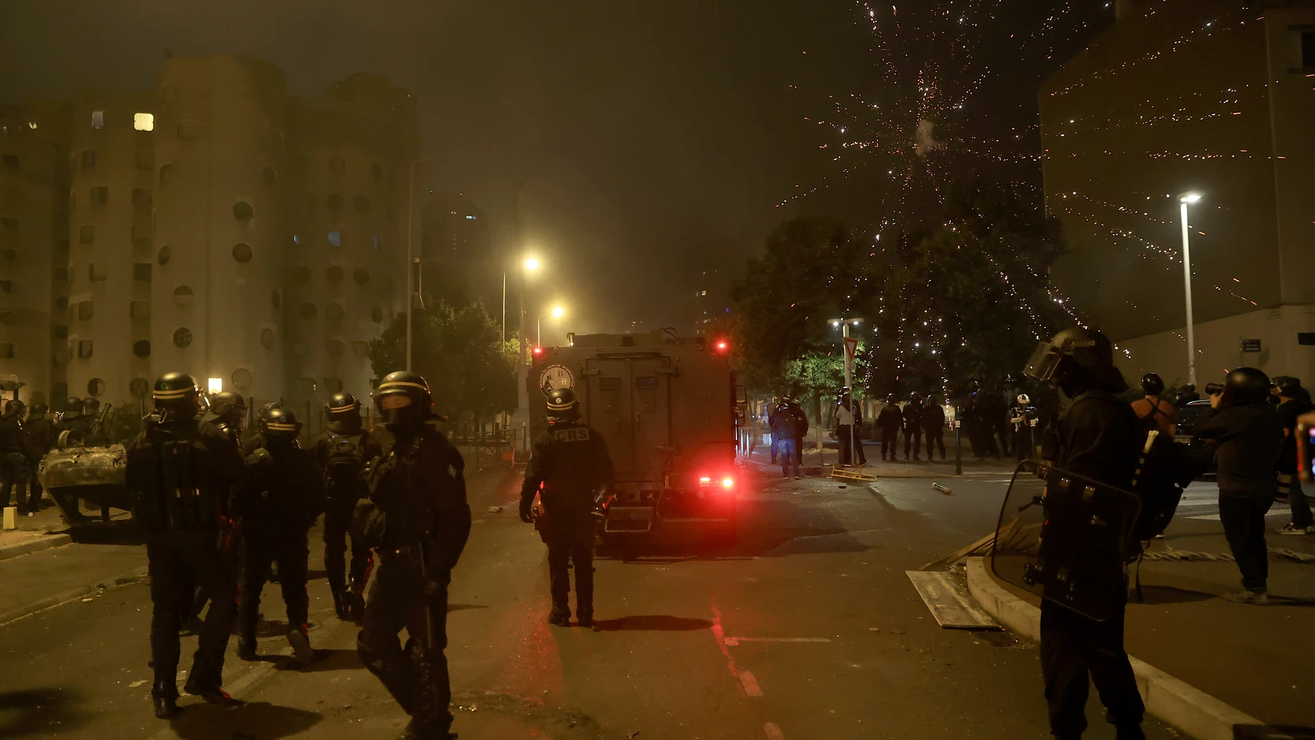 Riot police officers patrol on the third night of protests sparked by the fatal police shooting of a 17-year-old driver in the Paris suburb of Nanterre, France, Friday, June 30, 2023. The June 27 shooting of the teen, identified as Nahel, triggered urban violence and stirred up tensions between police and young people in housing projects and other neighborhoods. (AP Photo/Aurelien Morissard)