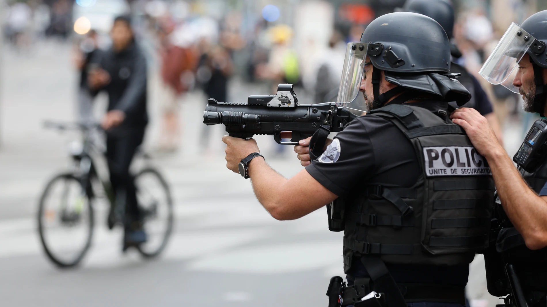 A police officer aims during a protest Friday, June 30, 2023 in Strasbourg, eastern France. French President Emmanuel Macron urged parents Friday to keep teenagers at home and proposed restrictions on social media to quell rioting spreading across France over the fatal police shooting of a 17-year-old driver that has resulted so far in the arrests of more than 800 people. (AP Photo/Jean-Francois Badias)