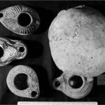 Lámparas de aceite y uno de los cráneos encontrados en la cueva.