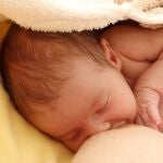 Un bebé es amamantado por su madre