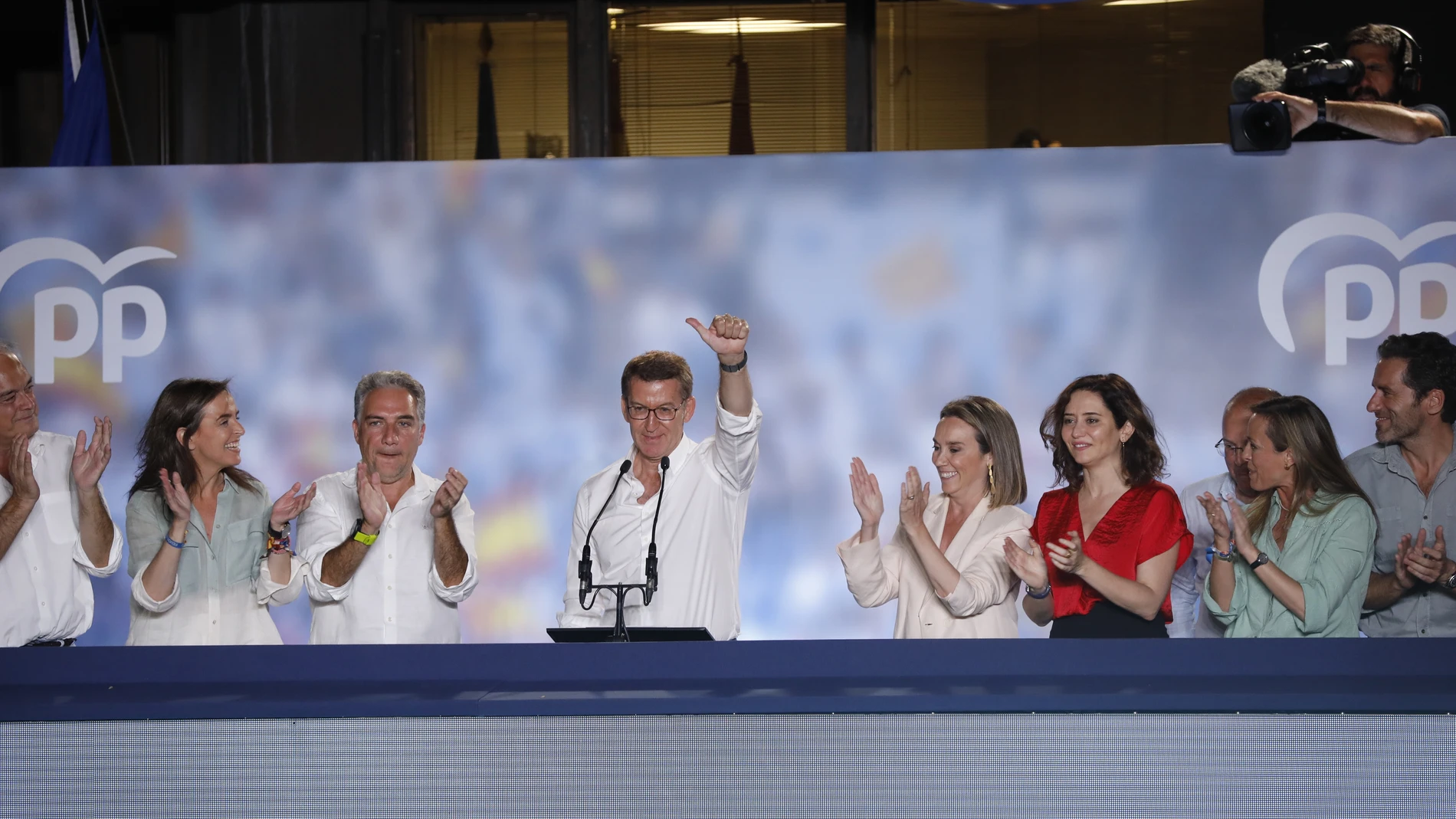 El candidato del Partido Popular, Alberto Núñez Feijoo (c), saluda a los simpatizantes en la sede de los populares en Madrid tras conocerse los resultados en las elecciones celebradas hoy domingo.
