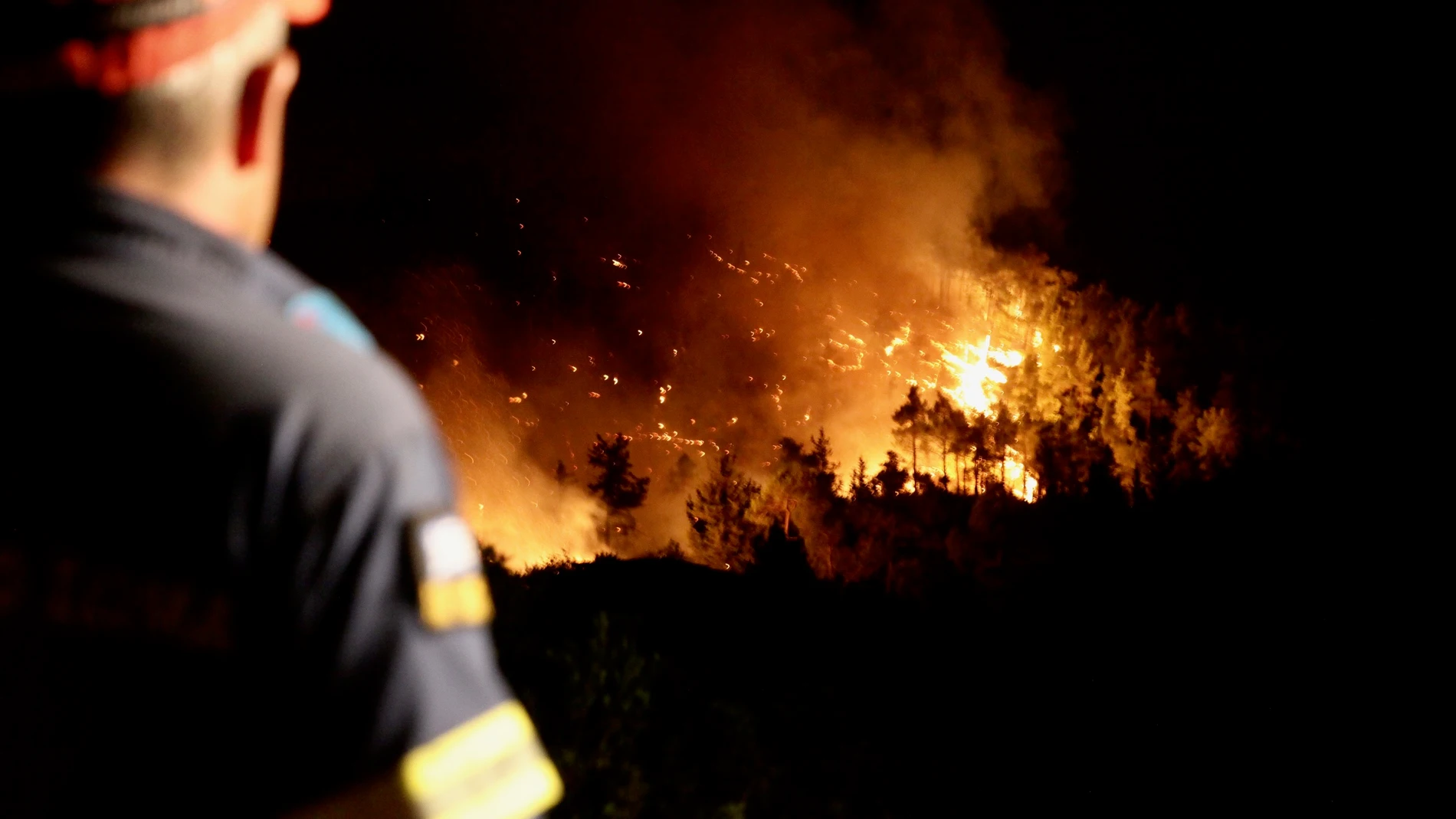 Un bombero observa un incendio forestal